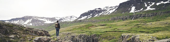 person standing at the foot of a mountain