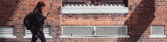 woman walking in front of a red brick building