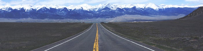 road leading to snow topped mountains